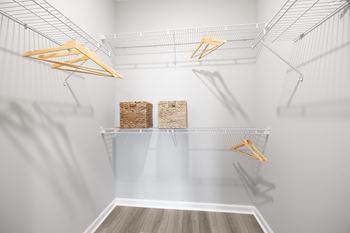 A white pantry with two shelves and hangers.